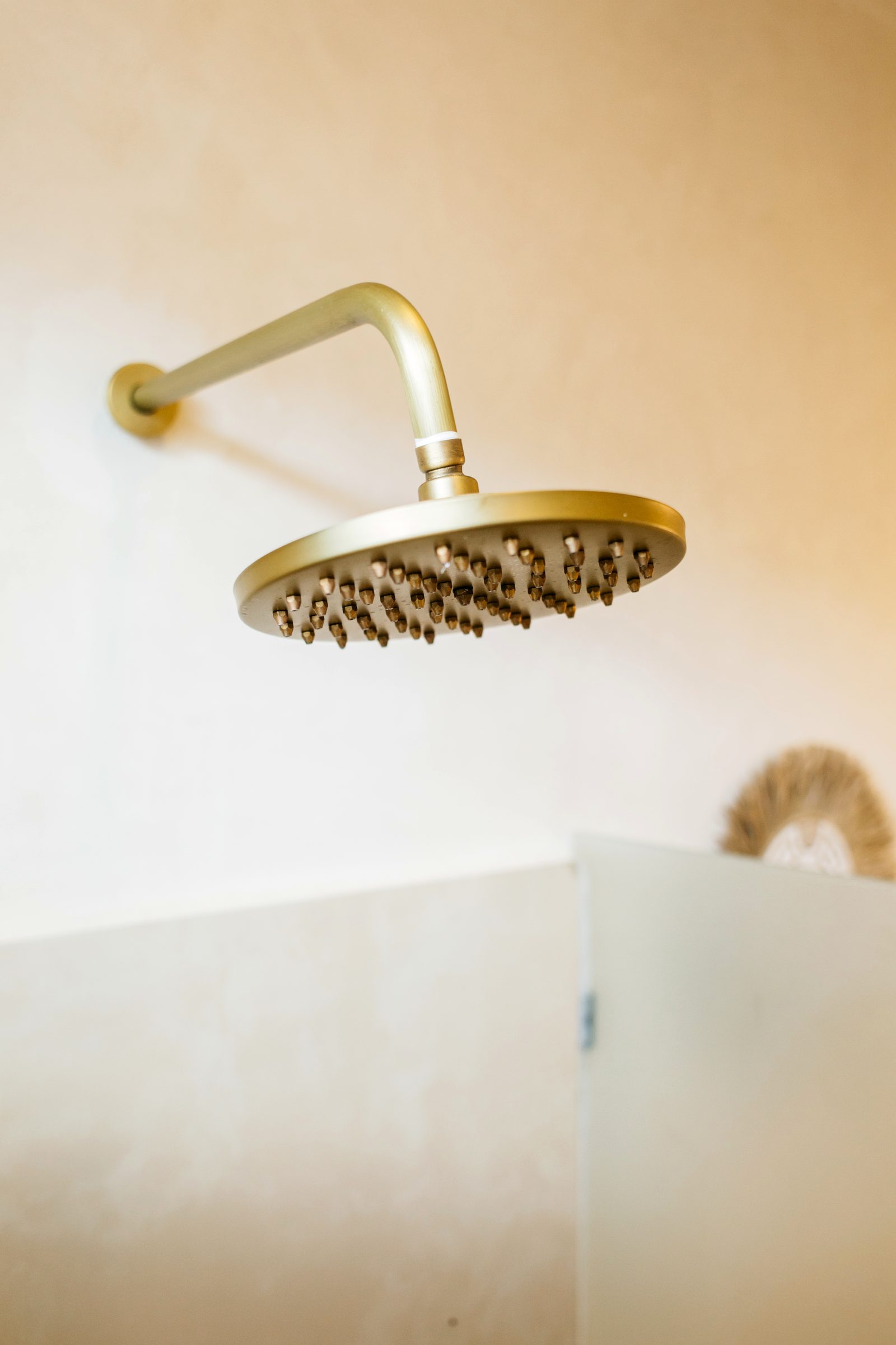 Brushed-brass rain shower — designer bathroom detail, Santara Villas Ubud Bali